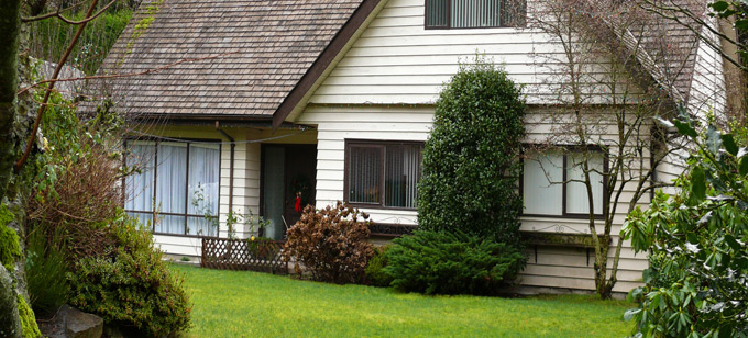 Single-family house with lawn and trees in front.