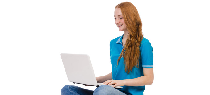Young woman sitting on floor working on laptop.