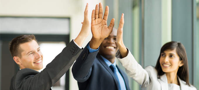 Business men and women hive five each other