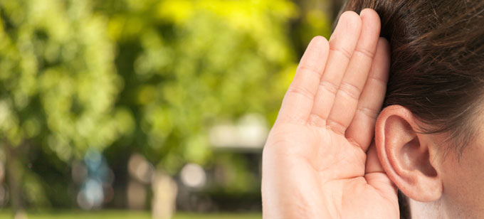 Person holding hand up to ear. Hear testimonials concept.